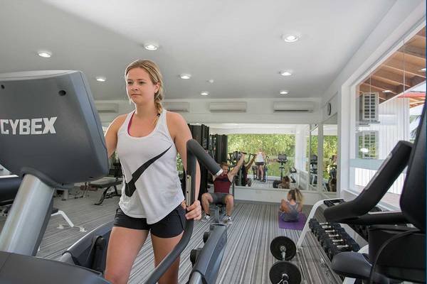 Frau trainiert auf einem Laufband im Fitnesscenter des Bandos Maldives Hotels.