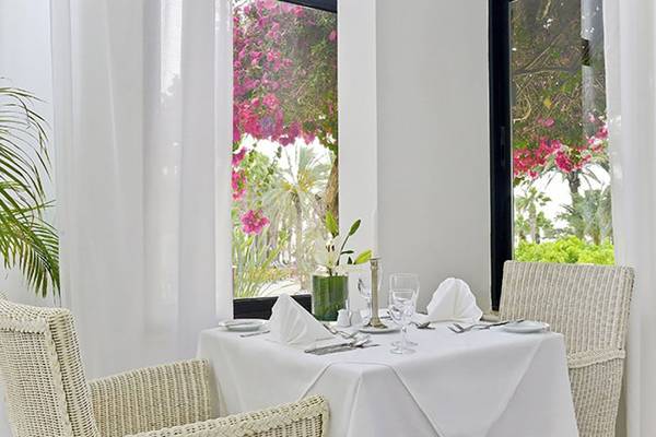 Ein eleganter Tisch im Azia Resort & Spa mit Blick auf Blumen und Grün.