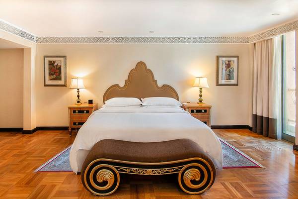 Schlafzimmer im Sheraton Abu Dhabi Hotel & Resort mit einem großen Bett, Nachttischen und Lampen.