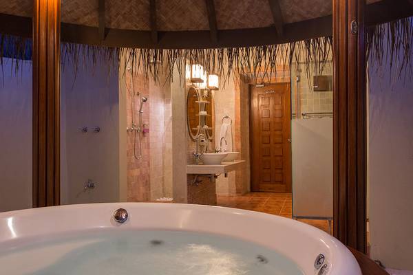 Badezimmer mit Whirlpool im Bandos Maldives Hotel mit offenem Dach