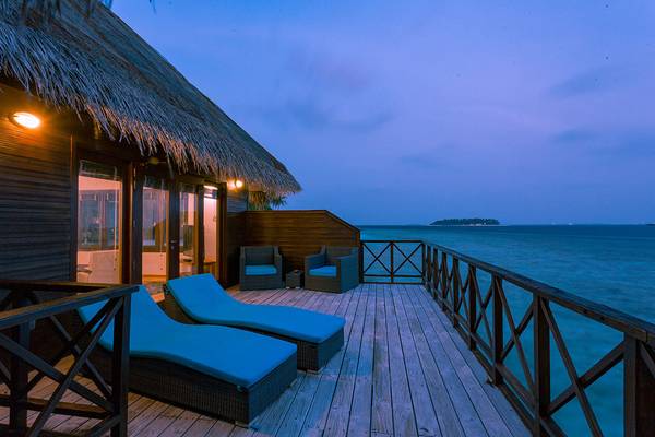 Abendansicht der Terrasse im Hotel Bandos Maldives mit Blick auf den Ozean.
