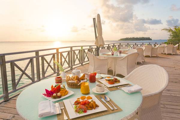 Frühstückstisch auf der Meeresterrasse im Hotel Bandos Maldives bei Sonnenaufgang