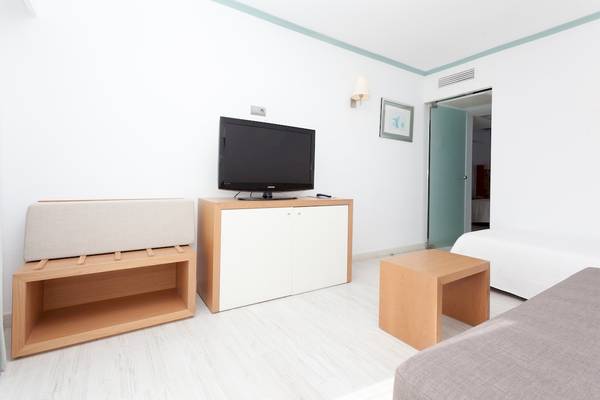 Innenansicht des Timor Hotels, mit Fernseher, Couch und Nachttisch