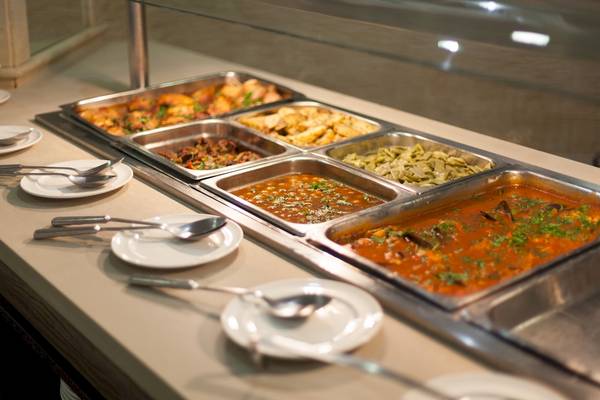 Buffet-Tisch im Timor Hotel mit verschiedenen Gerichten und Besteck.