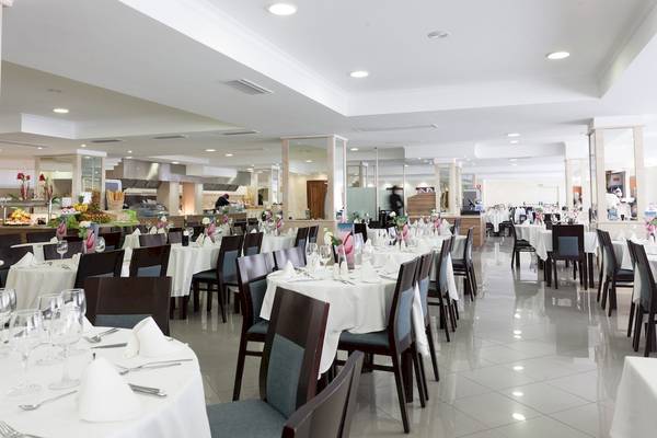 Innenansicht des Restaurants im Timor Hotel mit gedeckten Tischen und dekorierten Stühlen.