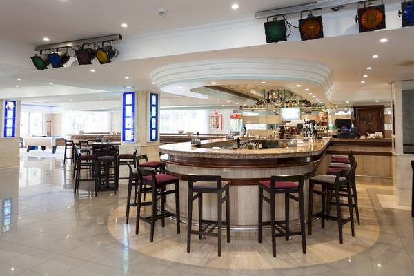 Innenansicht der Bar im Timor Hotel mit einer runden Theke und Hockern.