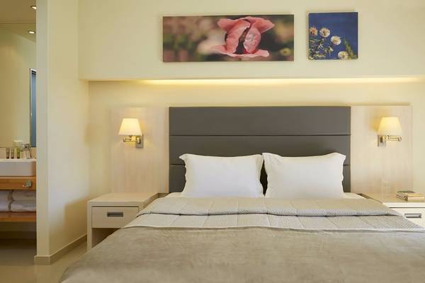 Schlafzimmer im Capo Di Corfu Hotel mit zwei weißen Kissen und zwei Nachttischen.