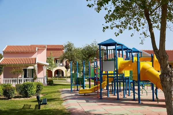Kinderspielplatz im Capo Di Corfu Hotel mit gelber Rutsche und bunten Spielgeräten.
