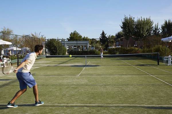 Tennisplatz im Hotel Capo Di Corfu mit Spielern, die Tennis spielen.