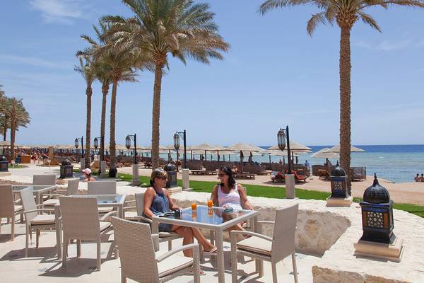 Zwei Frauen sitzen auf einer Terrasse des Makadi Spa Hotels und genießen Getränke.