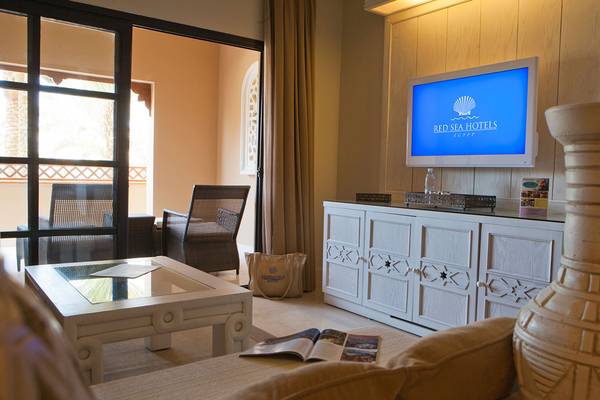 Wohnzimmer des Makadi Spa Hotels mit Fernseher, Couch, Tisch und Möbeln.