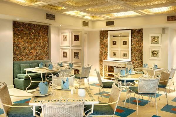 Innenansicht des Makadi Spa Restaurants mit geometrischem Bodenmuster, Steinwänden und eleganten Esstischen.