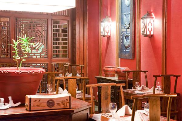 Innenraum des Makadi Spa Hotels mit Tisch und Stühlen, roter Wand und Lampen.