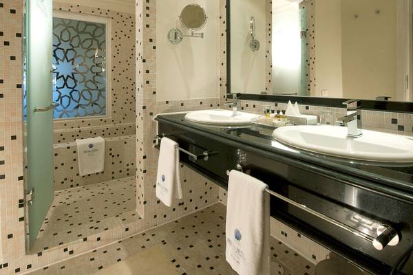 Das Badezimmer im Makadi Spa Hotel mit zwei Waschbecken, Spiegel und Dusche.