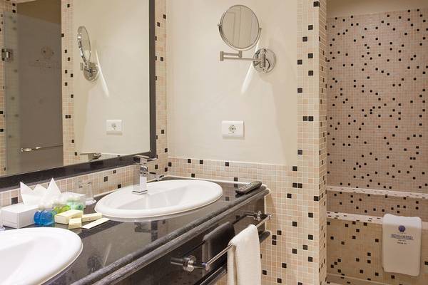 Ein Badezimmer mit zwei Waschbecken, Spiegeln, Toilettenartikeln und einem Badezimmerspiegel.