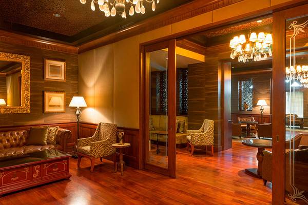 Loungebereich des Sheraton Abu Dhabi Hotel mit Holzboden, braunem Ledersofa und Dekorelementen.