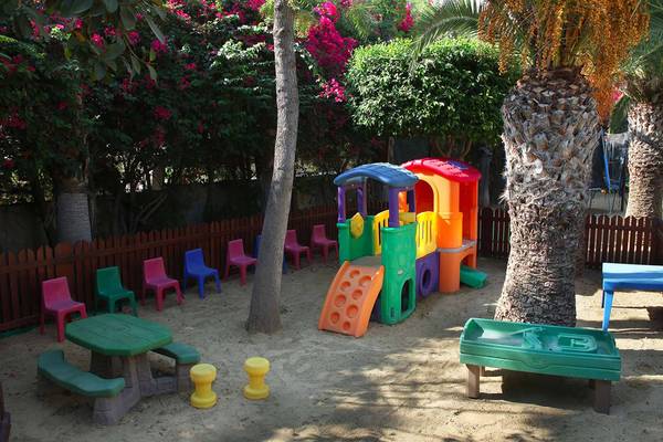 Kinderspielplatz im GrandResort Limassol mit bunten Spielgeräten und Sitzgelegenheiten.