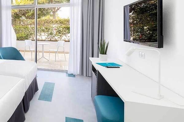 Doppelzimmer im Bluesea Interpalace mit zwei Betten, weißem Dekor und einem Balkon.