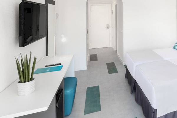 Hotelzimmer im Bluesea Interpalace mit zwei Betten, Fernseher, Schreibtisch und moderner Einrichtung.