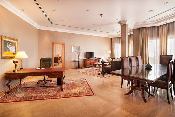 Innenraum des Sheraton Abu Dhabi Hotel & Resort mit Schreibtisch, Stühlen und Sofa.