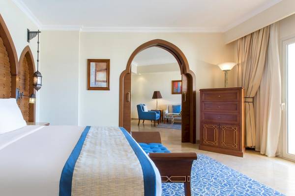 Schlafzimmer im Kempinski Hotel Soma Bay mit Doppelbett, Kissen und dekorativen Elementen.