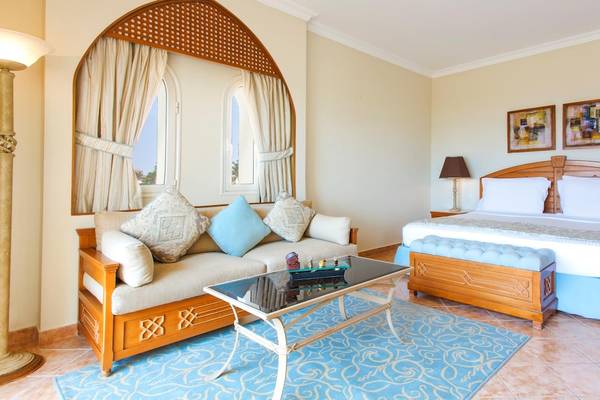 Innenansicht eines Zimmers im Kempinski Hotel Soma Bay mit Bett, Sofa und Tisch.