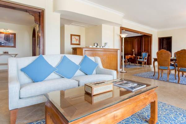 Wohnzimmer im Kempinski Hotel Soma Bay mit Sofa, Tisch, Esstisch und Stühlen.