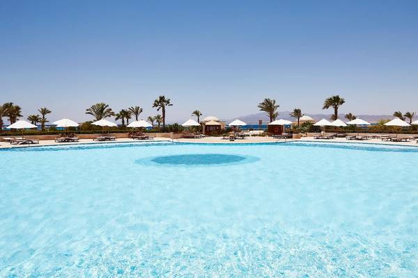 Außenpool des Kempinski Hotels Soma Bay mit vielen Sonnenliegen und Sonnenschirmen.