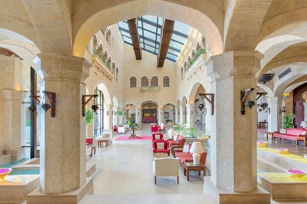Die geräumige und helle Halle des Kempinski Hotel Soma Bay mit Säulen, Sitzgelegenheiten und Pflanzen.