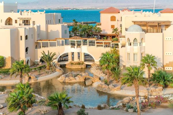 Außenansicht des Kempinski Hotels Soma Bay mit Blick auf den Ozean, Brücke und Palmen
