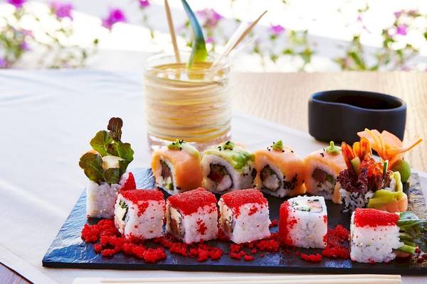 Eine Platte mit verschiedenen Sushi-Rollen auf einem Holztisch im Kempinski Hotel Soma Bay.