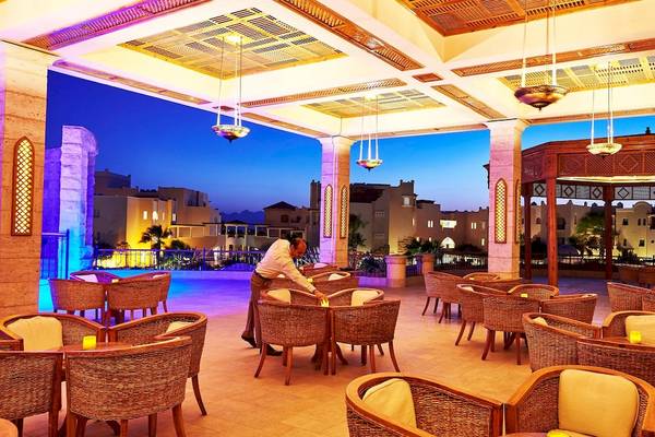 Terrasse des Kempinski Hotel Soma Bay mit abendlicher Beleuchtung und Blick auf die Stadt.