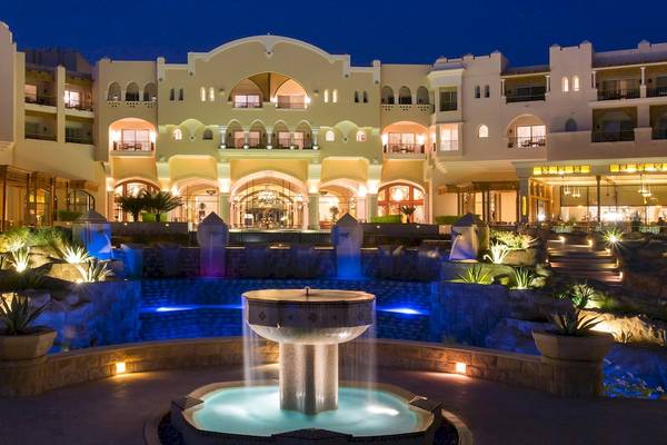Haupteingang des Kempinski Hotel Soma Bay bei Nacht mit Wasserbrunnen und Beleuchtung.