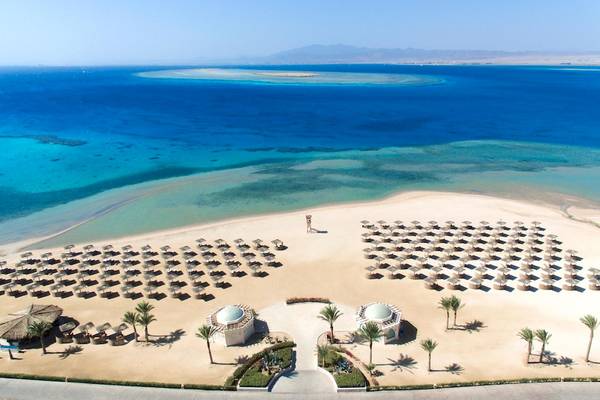 Luftaufnahme des Kempinski Hotel Soma Bay Strands mit vielen Sonnenschirmen und Palmen