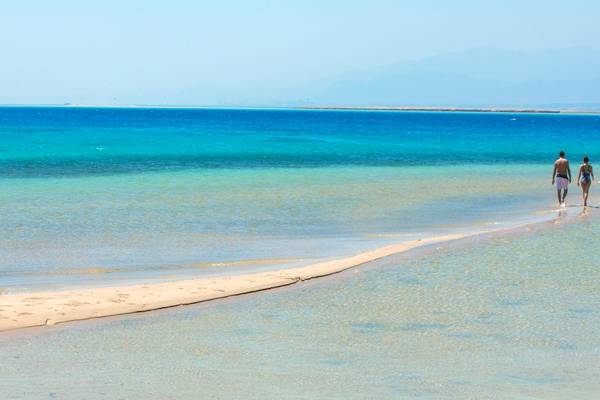Zwei Personen laufen am Strand von Kempinski Hotel Soma Bay