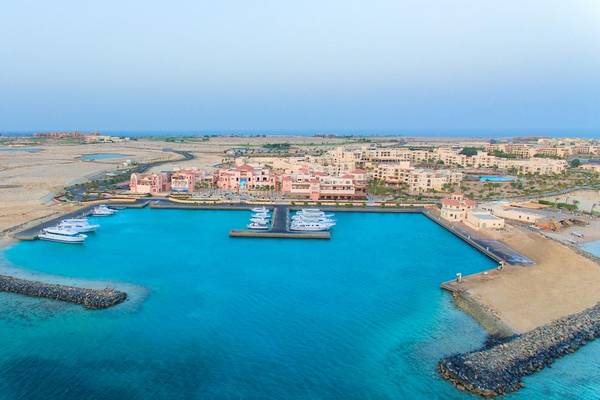 Luftaufnahme des Kempinski Hotel Soma Bay Hafens mit verankerten Booten und umliegender Landschaft.