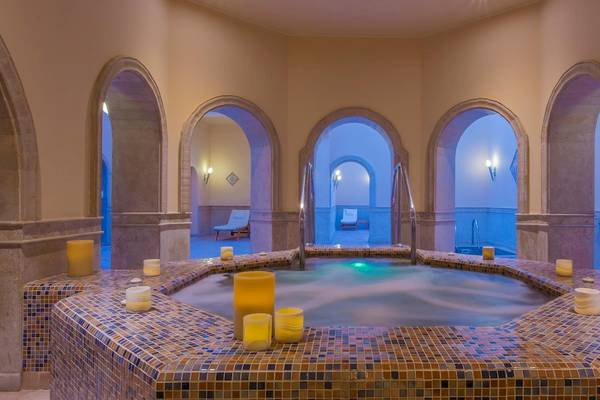 Wellnessbereich im Kempinski Hotel Soma Bay mit einem großen Whirlpool und farbigen Kacheln.