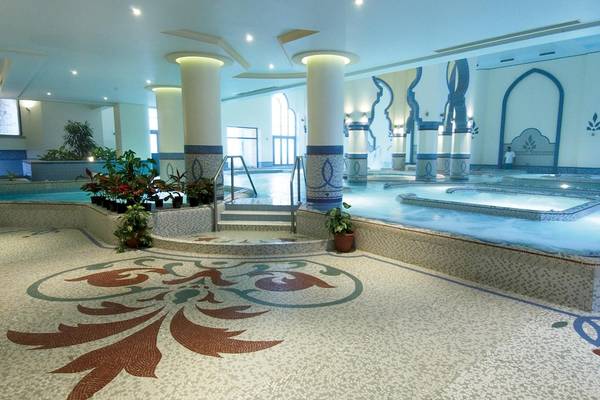Innenpoolbereich des Kempinski Hotels Soma Bay mit zwei Becken, Säulen und Pflanzen.