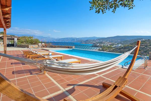 Terrasse des Miramare Resort & Spa mit Hängematte und Pool mit Blick auf das Meer und Berge