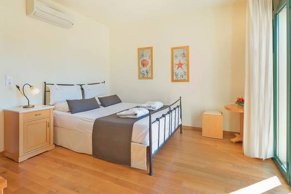 Schlafzimmer im Miramare Resort & Spa mit Bett, Nachttisch und Klimaanlage.