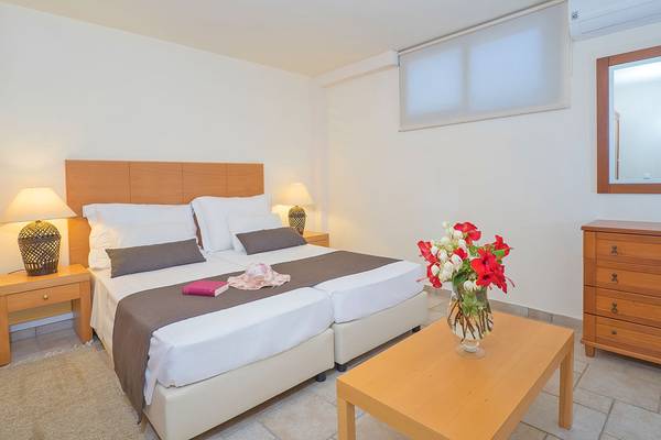 Doppelzimmer im Miramare Resort & Spa mit zwei Betten, Lampen, einem Tisch mit Blumenvase und einem Kleiderschrank.