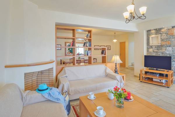 Wohnbereich im Miramare Resort & Spa mit Sofas, Kamin, Bücherregal, Fernseher und Tisch mit Kaffee.