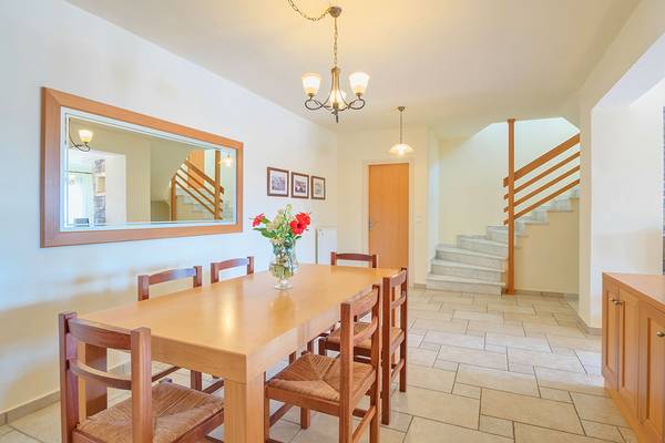 Speisezimmer mit Tisch, Blumen, Spiegel und Treppe im Miramare Resort & Spa.