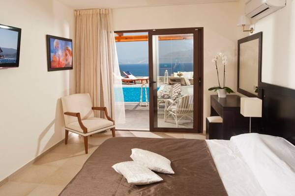 Schlafzimmer im Miramare Resort & Spa mit Blick auf den Pool und das Meer.
