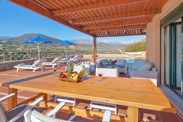 Terrasse des Miramare Resorts mit Lounge-Sesseln, einem Pool und Blick auf die Berge.