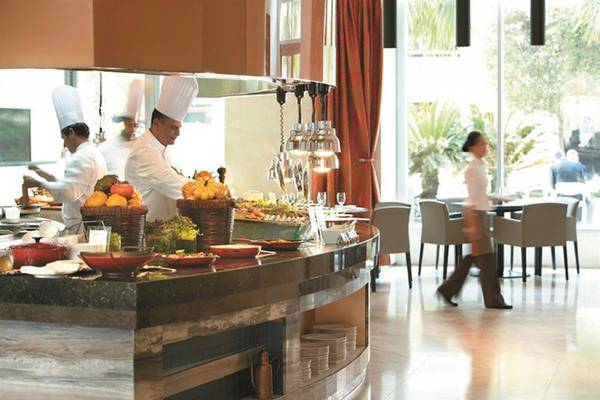Buffetbereich im Shangri-La Hotel Dubai mit Köchen, die Speisen zubereiten, und Gästen, die vorbeigehen.