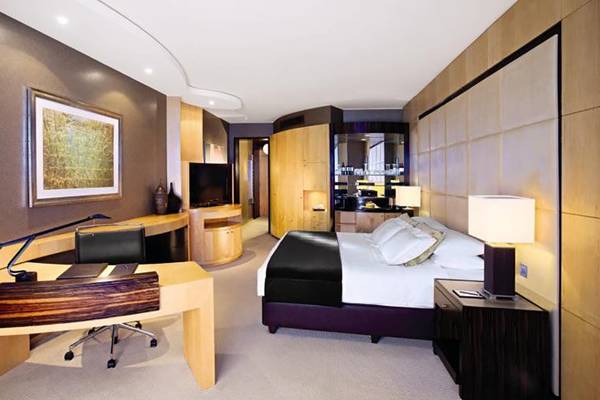 Luxuriöses Hotelzimmer im Shangri-La Dubai mit Schreibtisch, Bett und Fernseher.
