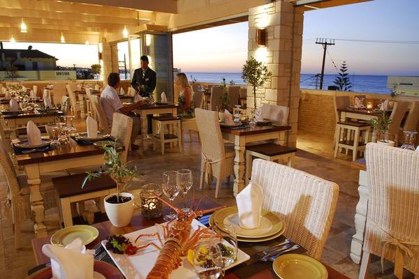 Restaurantterrasse des Cactus Royal Hotels mit Blick auf das Meer und Gästen, die sitzen und essen.