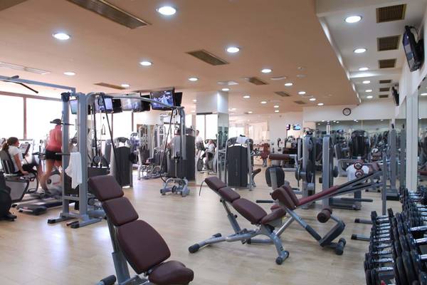 Fitnesscenter im Cactus Royal Hotel mit verschiedenen Trainingsgeräten und Spiegeln.