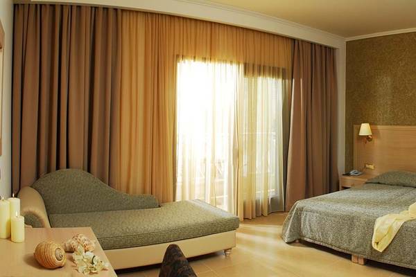 Hotelzimmer im Cactus Royal mit einem Bett, einem Schlafsofa, Tisch und Kerzen.